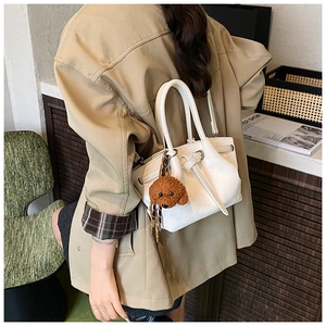 Détail du sac seau blanc plissé avec fines anses et breloque caniche en peluche marron