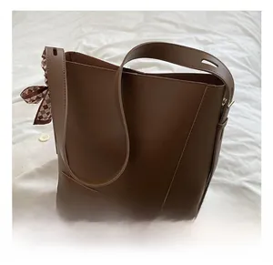 Detailed macro view of a brown bucket bag with a stylish checkered ribbon on the handle