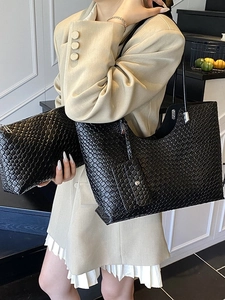 Sac fourre-tout noir tressé minimaliste avec pochette porté par un mannequin