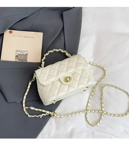 Détail du sac à rabat matelassé blanc avec chaîne dorée et fermoir rotatif en métal