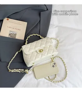 Sac à rabat blanc matelassé à côté d'un smartphone pour comparer la taille