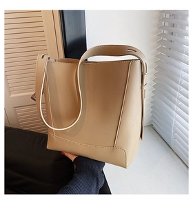 Detail of beige PU leather tote bag showing adjustable shoulder strap and vertical seams