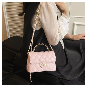 Sac bandoulière matelassé rose avec fermoir doré et anse en perles sur un mannequin