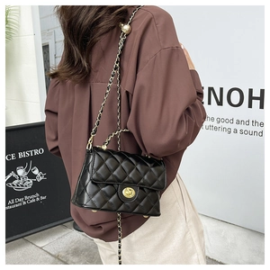 Détail du sac matelassé noir avec bandoulière chaîne dorée et fermoir métallique chic