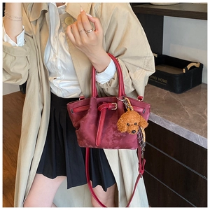 Détail du sac seau bordeaux texturé avec une jolie peluche d'ours en peluche