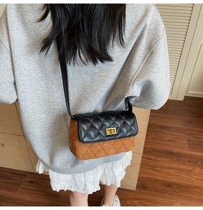 Crossbody view of the black and brown quilted square bag with gold twist lock