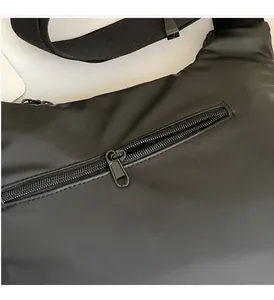 Close-up of smooth black metal zipper and durable nylon fabric on fashion crossbody bag