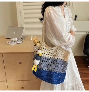 Detail of hand-woven crochet tote with gradient stripes and a cute duckling charm