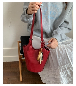 Chic red faux crocodile skin bucket bag with vintage beaded charm and wood texture details