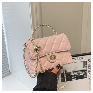 Détail d'un sac bandoulière rose matelassé avec fermoir rotatif doré et anse chaîne