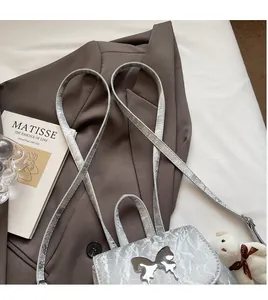 Close-up of silver wrinkled texture backpack with metallic butterfly and long shoulder strap