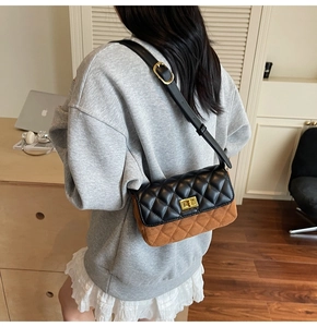 Detail of crossbody bag with quilted diamond pattern and metallic turn-lock closure