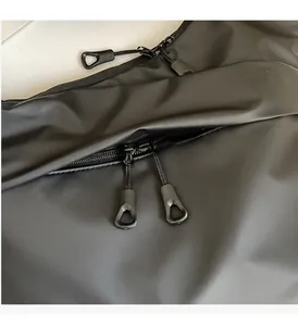 Macro detail of the waterproof black shoulder bag featuring smooth double zippers and pulls