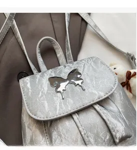 Detail of silver metallic backpack with liquid butterfly hardware and wrinkled texture