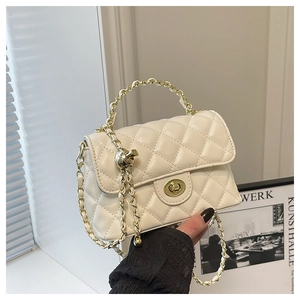 Détail du sac à bandoulière matelassé beige avec chaîne dorée et fermoir pivotant