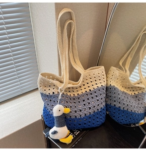 Detailed knit texture of gradient crochet tote bag with a cute seagull plush pendant