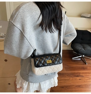 Close-up of quilted pattern stitching and gold metal twist lock on a square bag