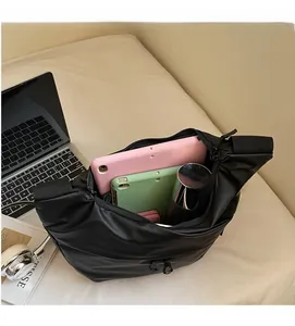 Spacious black nylon crescent bag showing interior capacity for tablet and water bottle