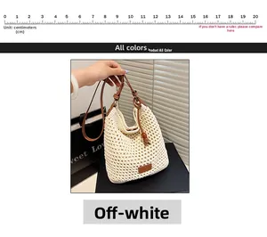 Detail of woven straw tote bag with brown leather strap and decorative wooden beads