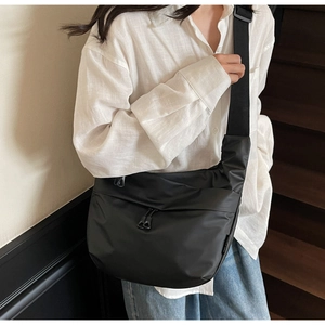 Detail of adjustable drawstring buckle and water-resistant nylon texture on shoulder bag