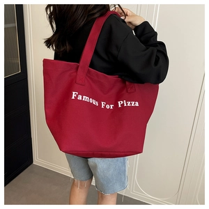Dettaglio della borsa tote in tela bordeaux con stampa Famous For Pizza e tracolla robusta