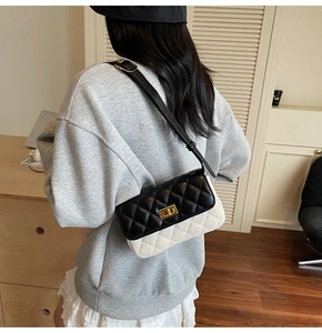 Close-up of retro quilted crossbody bag with gold lock and adjustable strap on a model