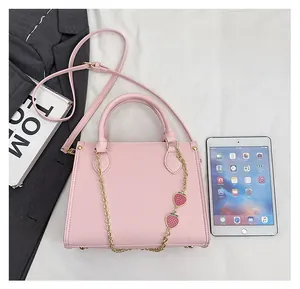 Petit sac fourre-tout rose avec chaîne dorée à fraises et détails de bandoulière longue