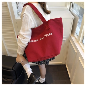 Dettaglio della borsa shopper in tela rossa con stampa del testo Famous For Pizza