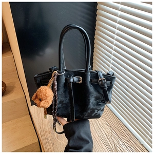 Détail d'un mini sac cabas noir en daim avec un pendentif chien et corde tissée