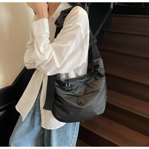 Close-up of durable black nylon crossbody bag with adjustable wide strap and plastic buckle