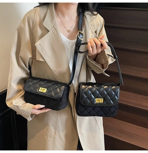 Detail of classic black quilted crossbody bag with gold square twist lock on shoulder strap