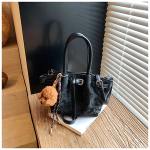 Détail du sac seau noir en daim avec cordon de serrage et breloque en peluche de chien