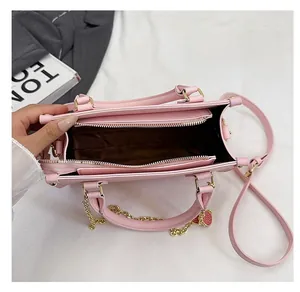 Vue de dessus du sac en cuir rose montrant les compartiments et le pendentif coeur