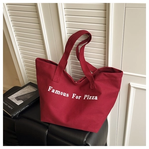 Dettaglio della borsa tote in tela rossa con stampa Famous For Pizza e manici robusti