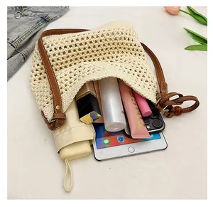 Top-down view of a spacious woven beach tote bag with brown leather straps and summer items