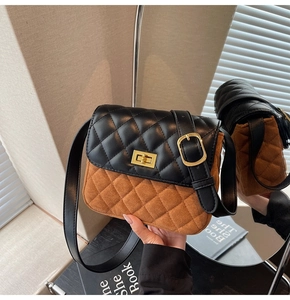Detail of vintage rhombic quilted shoulder bag with gold metal lock and brown suede texture