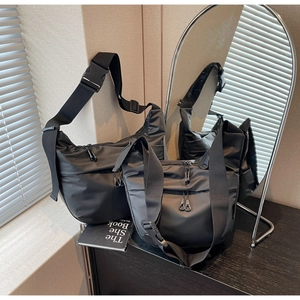 Close-up of black crossbody bag featuring adjustable wide strap and quick-release buckle