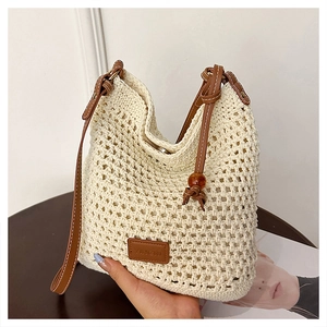 Detail of woven beach tote showing cotton mesh texture and brown leather strap with beads