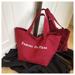 Dettaglio della borsa tote in tela rossa con stampa bianca Famous For Pizza