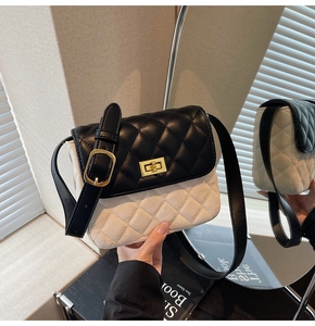 Detail of classic black and white quilted crossbody bag with gold-tone twist lock and strap