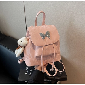 Detail of pink marble textured leather backpack with a silver butterfly buckle and bear charm