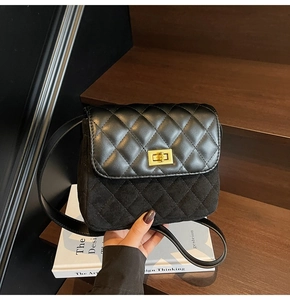 Detail of black quilted crossbody bag with golden twist lock and mixed leather texture