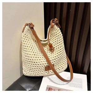 Detailed close-up of ivory crochet weave pattern and brown leather handle on a tote bag
