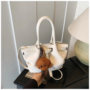 Vue détaillée du sac bourse blanc en similicuir avec cordon et breloque ours peluche