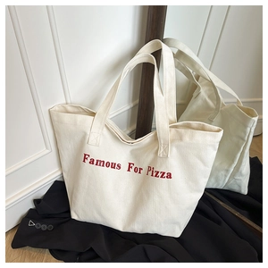 Dettaglio ravvicinato della borsa tote in tela crema con stampa rossa Famous For Pizza