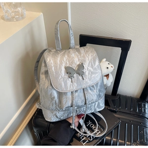 Detail of silver metallic backpack with crinkled texture and butterfly buckle