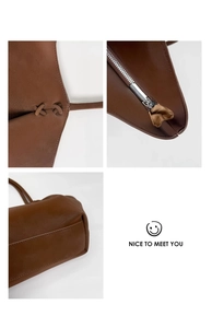 Détails du sac cabas en cuir marron montrant les coutures croisées et la fermeture éclair