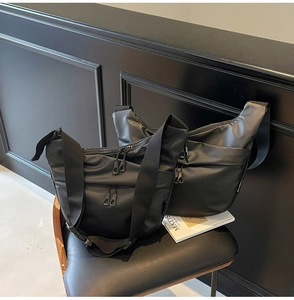 Close-up of waterproof nylon shoulder bag with multi-zipper pockets and wide strap