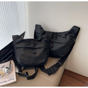 Detail of waterproof nylon crossbody bags in two sizes with functional zipper pockets