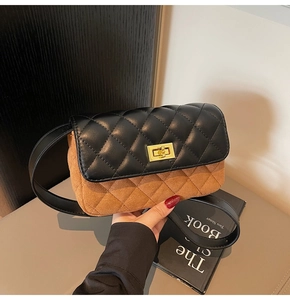Detail of contrast stitch diamond pattern and gold twist lock on bicolour crossbody bag